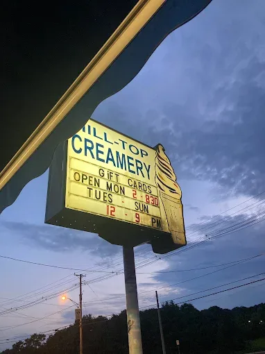 Hilltop Creamery roadside sign lit up at night on Post Road in East Greenwich, Rhode Island